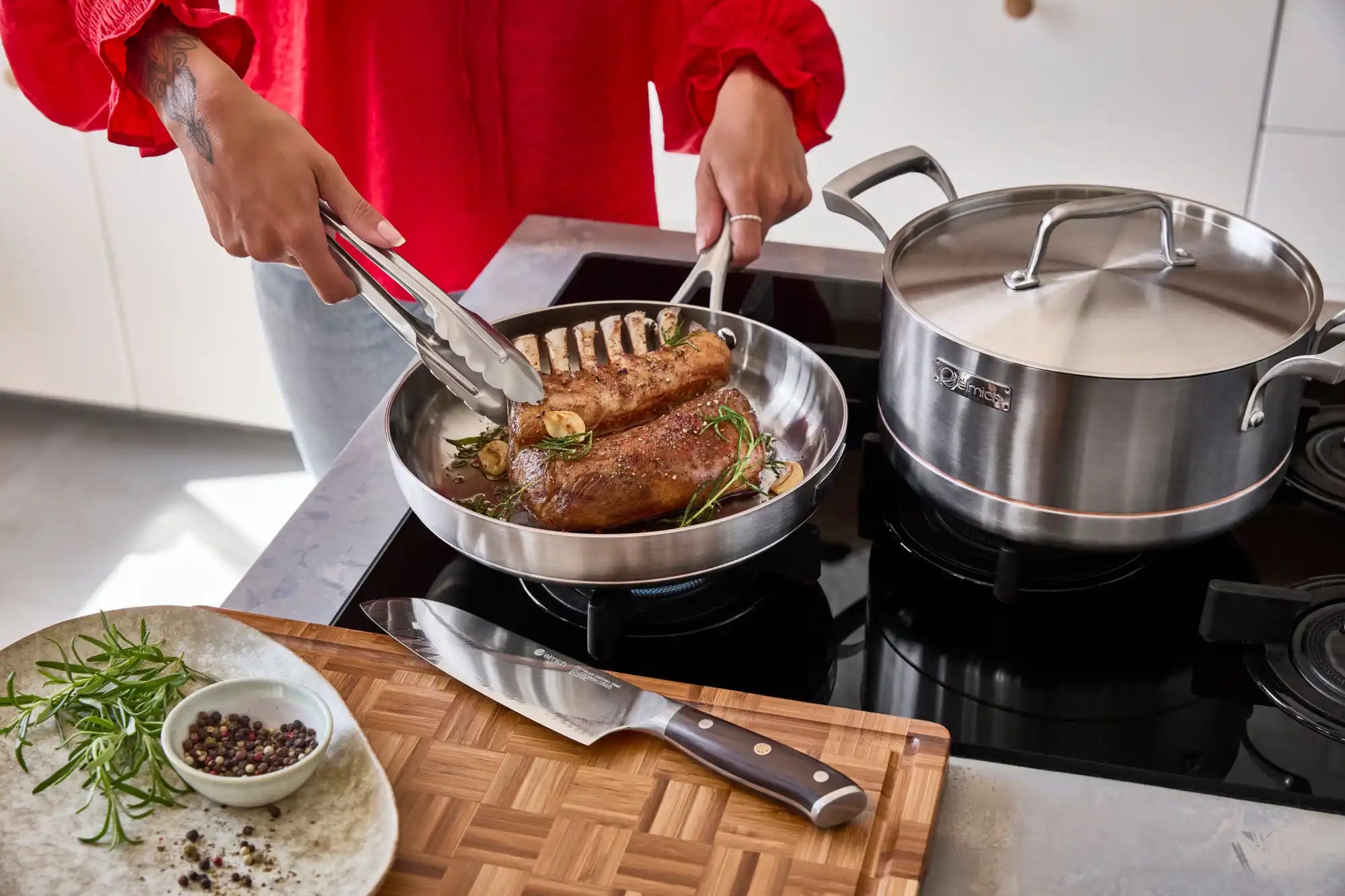 Nerezové nádobí na černé varné desce.