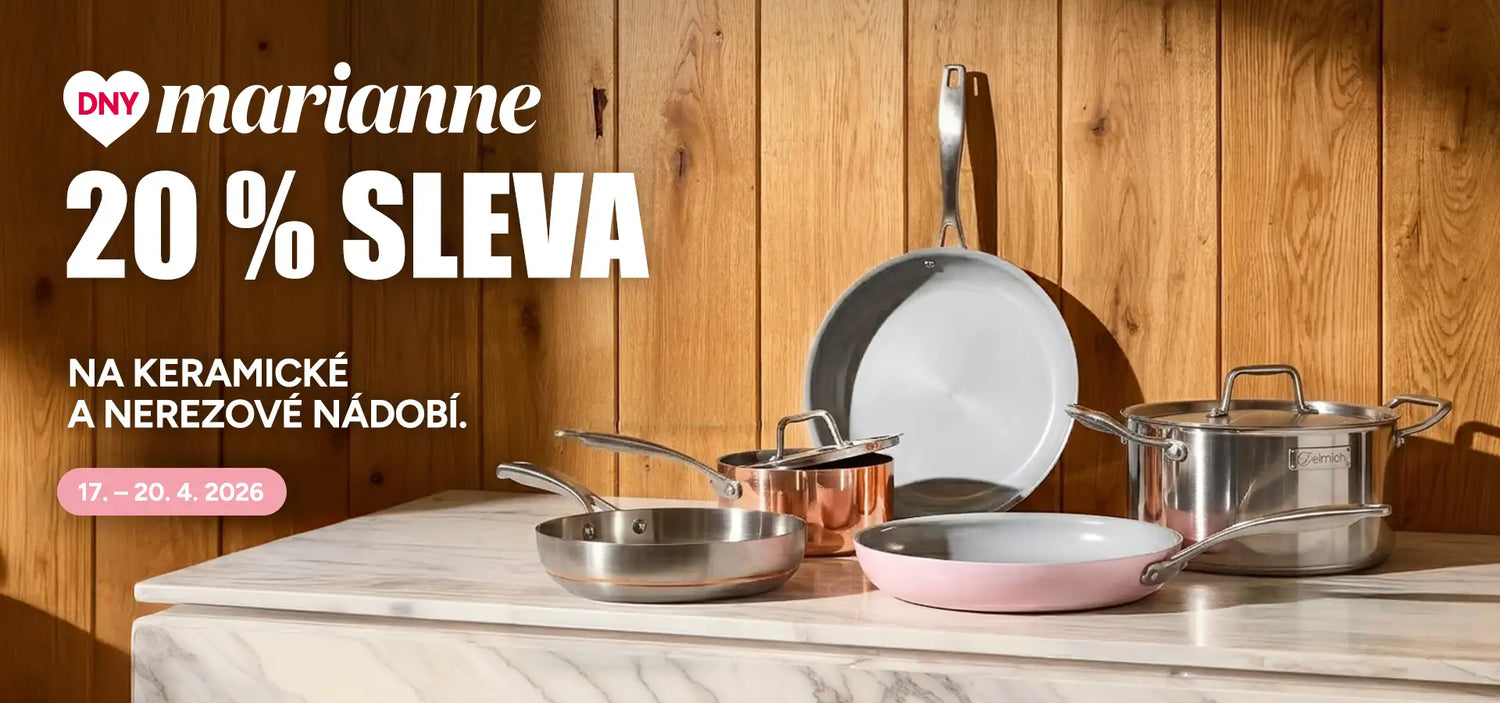 Sada keramického a nerezového kuchyňského nádobí s růžovou nepřilnavou pánví, měděným hrncem a stříbrnými pánvemi uspořádanými na mramorovém pracovním desku.